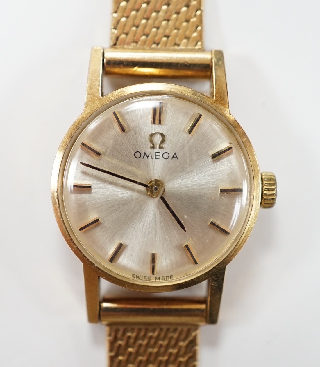 A lady's modern 9ct gold Omega manual wind wrist watch, on an associated 9ct gold bracelet, overall 18cm, gross weight 21.8 grams. Condition - fair